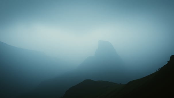 UniverseX - a mountain scene with a lone bird flying in the sky