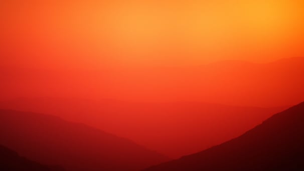 UniverseX - a plane flying over a mountain range at sunset