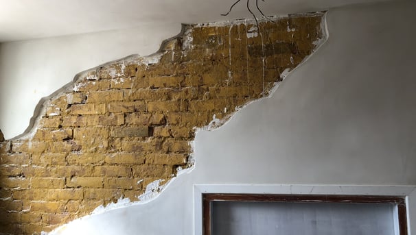 Decoratief stucwerk met zichtbare bakstenen.