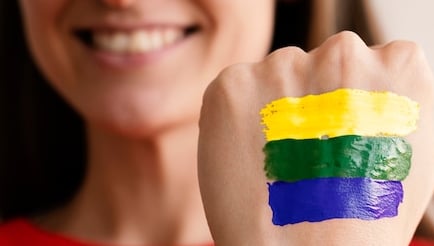 a woman with a rainbow - colored painted on her hand