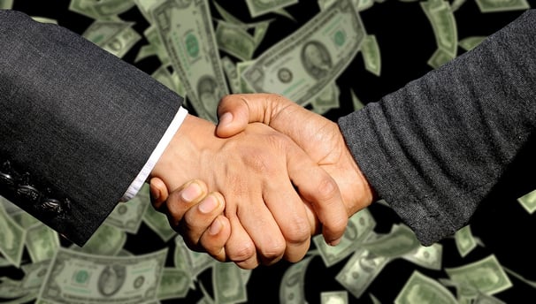 two people shaking hands with money bills and money