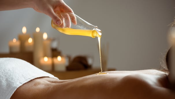 Massage huiles BIO sur le dos d'une femme - Massage Ayurvédique