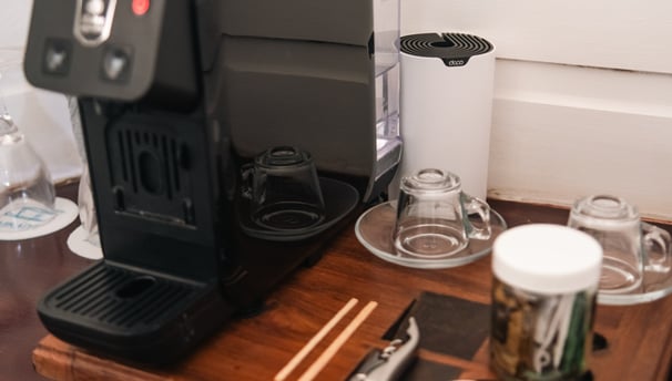 a coffee maker on a table with a cup of coffee