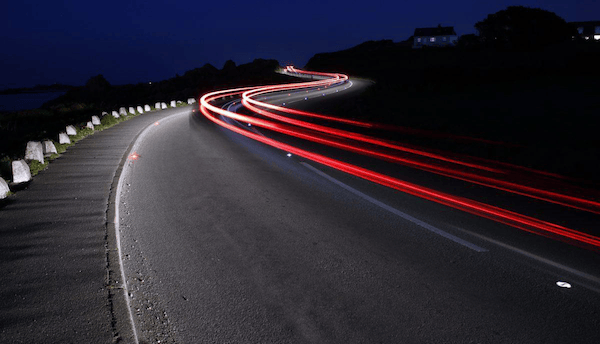 a car driving down a road at night with solar powered illumination