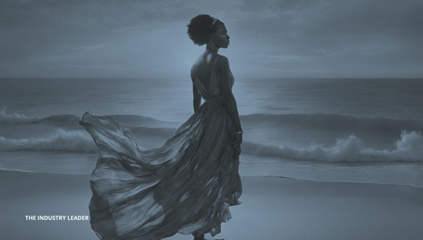 a woman in a dress standing on a beach