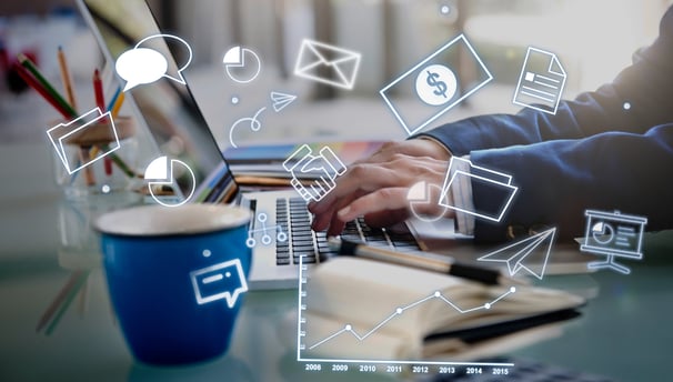 Person working on a laptop with superimposed icons signifying digital marketing, online communicatio