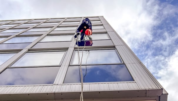 a person in a blue shirt is hanging from a rope