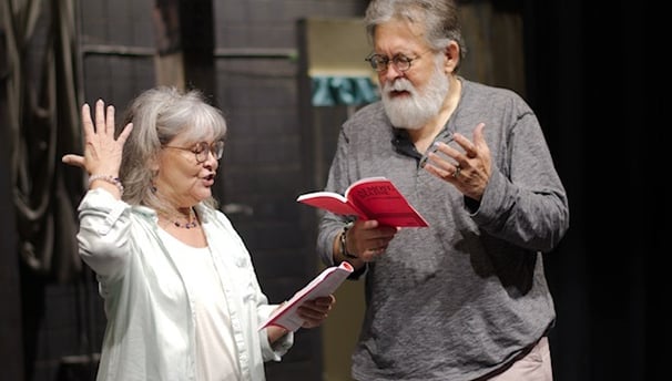 a man and woman standing in front of a stage