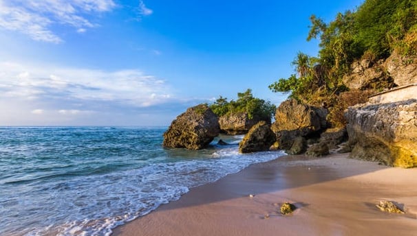 Padang Padang Beach with a rocky shore and a blue sky