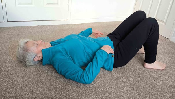 woman lying on carpet with knees raised