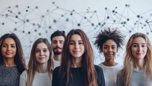 A diverse group of young adults stands in front of a white backdrop covered in interconnected nodes 