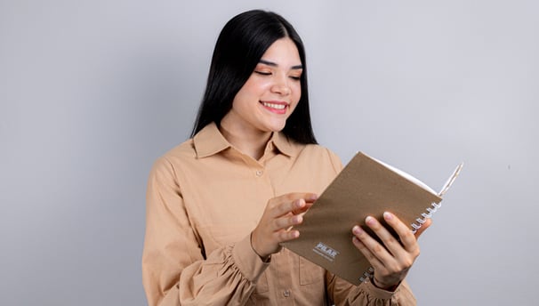 a woman in a brown shirt is holding a book