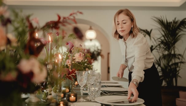 a woman is setting a table with a plate of food