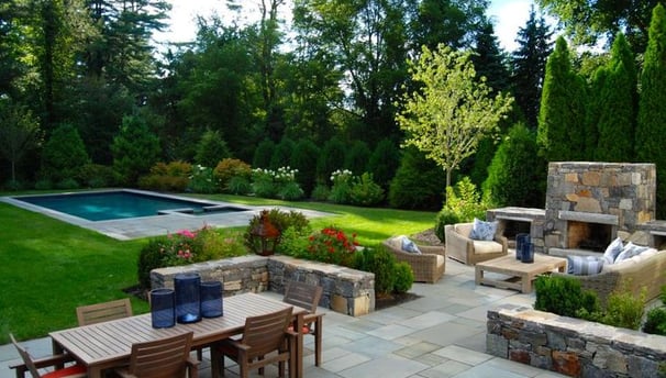 a patio with a table and chairs and a fireplace