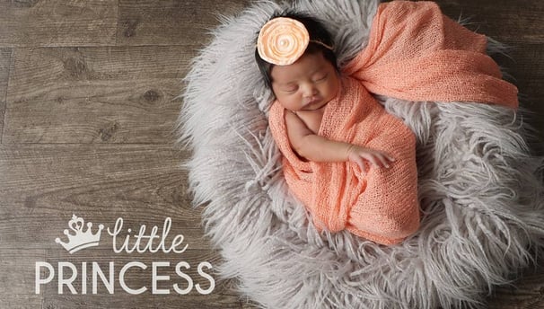 a newborn girl sleeping in a blanket on a blanket