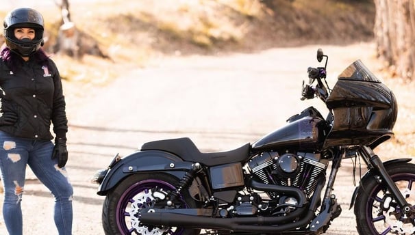 woman standing by black motorcycle