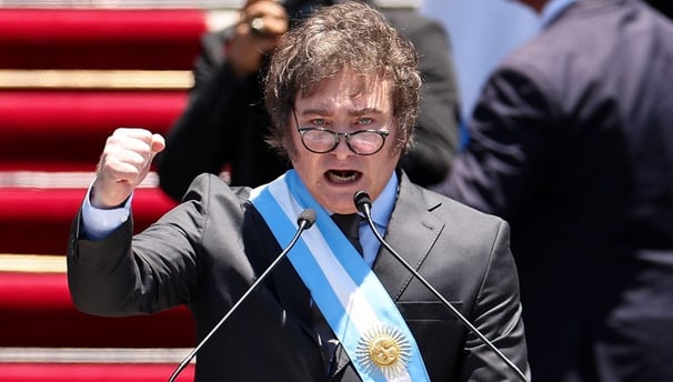 a man in a suit and tie is holding a microphone