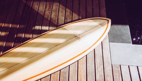 Handmade balsa surfboard resting on a wooden deck