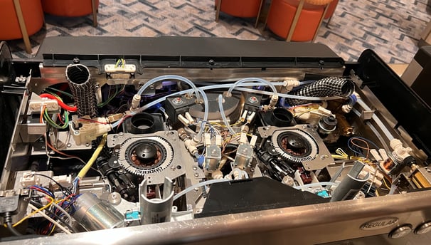 Internal top view of a Schaerer Barista coffee machine showing tubing and brewer unit.