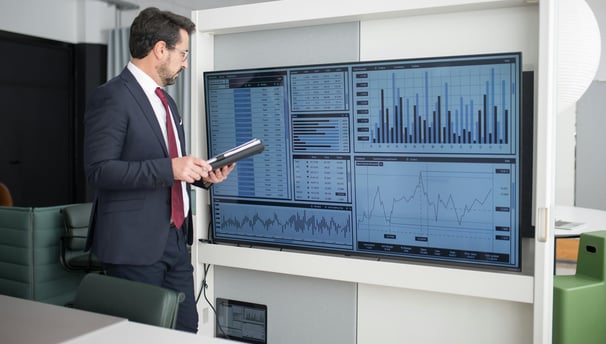 a man in a suit and tie is holding a tablet computer