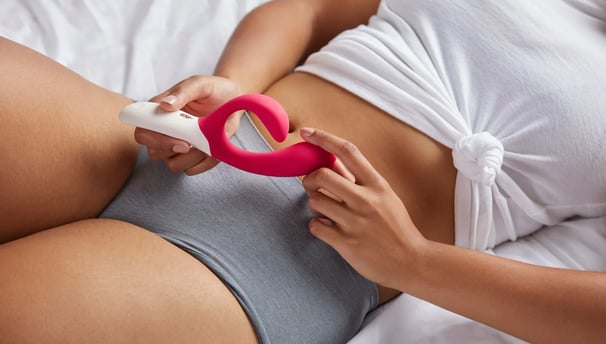 a Hela Ads woman in a white shirt and panties is holding a pink object