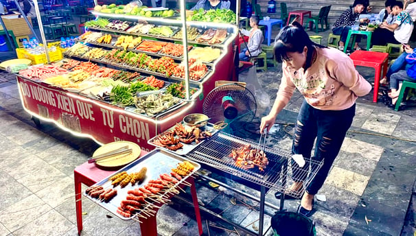 a street vendor is cooking food on a grill