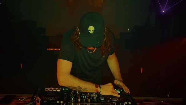 a man in a hat and a hat on a dj booth