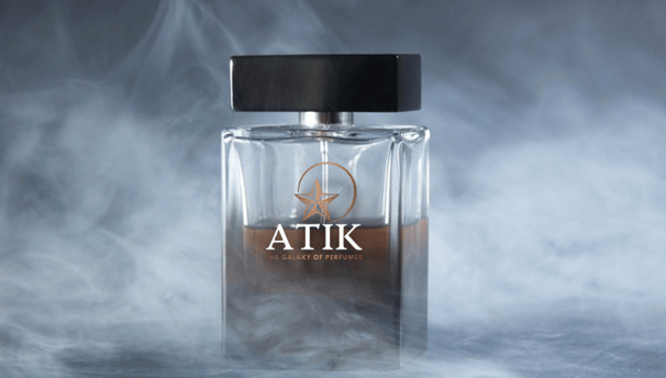 a bottle of atik perfume on a smokey background