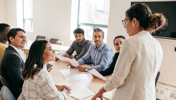 a woman talking to a table full of colleagues