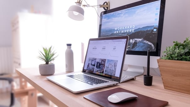 MacBook Pro on table beside white iMac and Magic Mouse