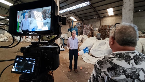 a man is standing in a warehouse with a camera and a video camera