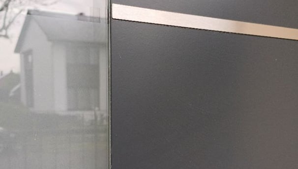 a black and white door with a window and a fence