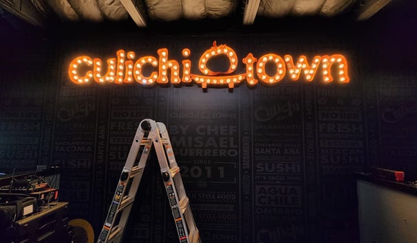 a ladder up to a sign that says culichi town