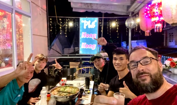 a group of people sitting at a table with food