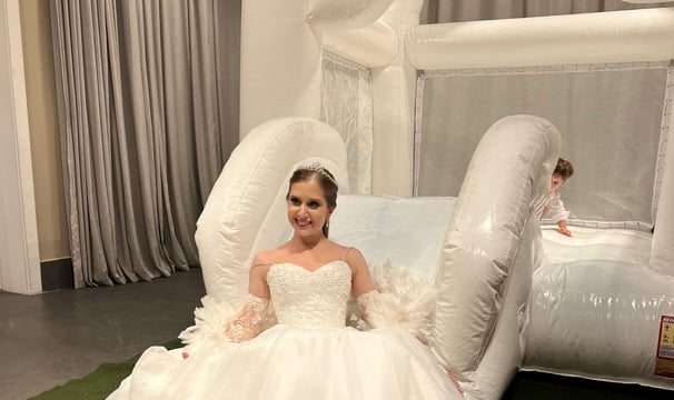 Noiva em frente a um inflável branco comemorando seu casamento