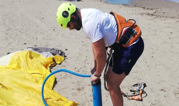 Allievo principiante intento a gonfiare una vela di kitesurf