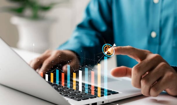 a man is pointing at a bar chart in a financial software