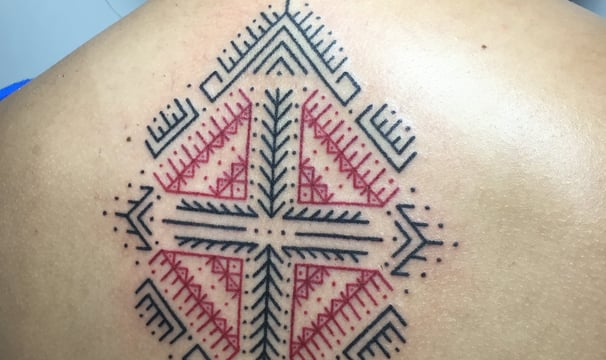 An handpoke tattoo featuring art ornaments songket melayu inspired. A girl with tatoo on back