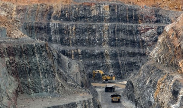 a large amount of rock is being worked on by a truck