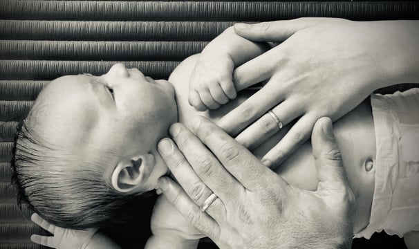 a couple holding hands with their baby