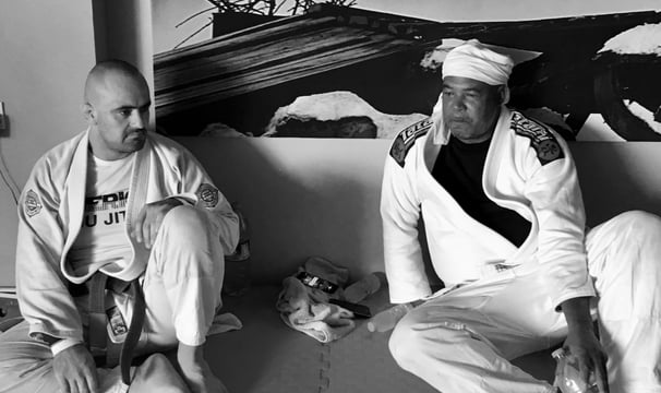 two men sitting on the mat
