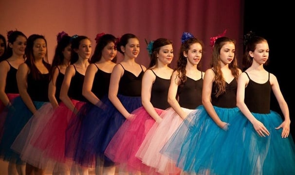 a group of young girls in colorful tulle skirts and tututututu