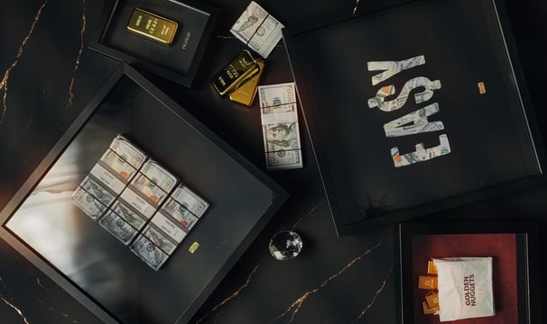 frames and artwork with money and gold bar in a marble background