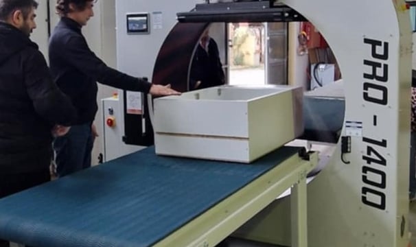 a man standing in front of a machine that is cutting into a piece of paper