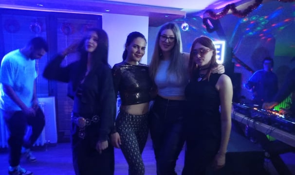 a group of people standing around a dj booth