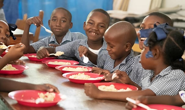 Young kids enjoy a school program offering meals to students for lunch