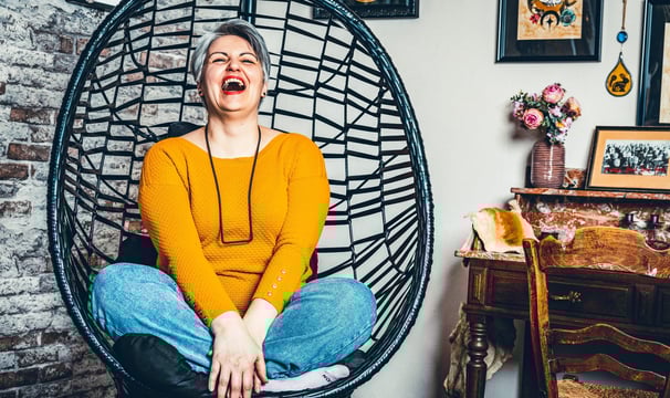 a woman sitting in a chair with a smile on her face