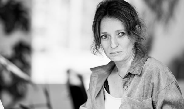 a woman sitting at a table with a cup of coffee