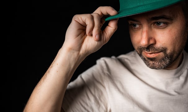 a man in a green hat with a baseball cap on