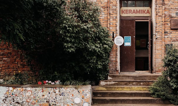 Old red brick house with open doors. On top of it is written: ceramics. 